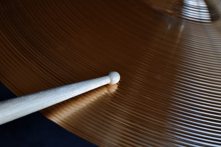 Close-up of a drumstick striking a shiny cymbalの写真素材