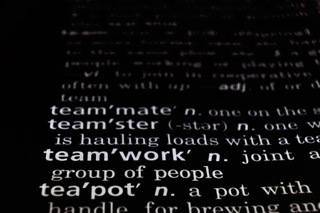 The word teamwork in a dictionary, white on blackの写真素材