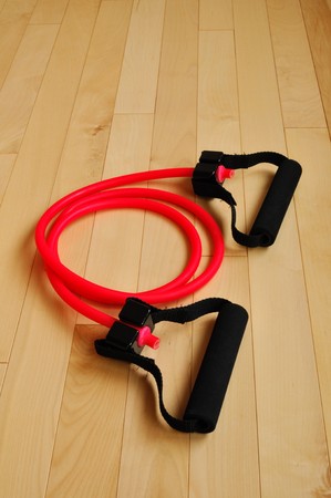 Red Resistance Band on Fitness Center Floor, vertical