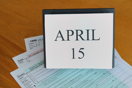 April 15 on desk calendar, 1040 tax forms