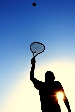 Silhouette of Teen Girl Serving a Tennis Ball, veritcal, copy spaceの写真素材