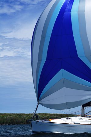 Sailboat with blue spinnaker Sail on a beautiful summer day, verticalの写真素材