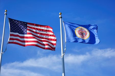 United States and Minnesota State Flags Against a Blue Skyの写真素材