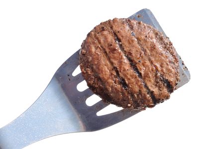 Grilled Hamburger Patty on a Spatula Isolated on Whiteの写真素材