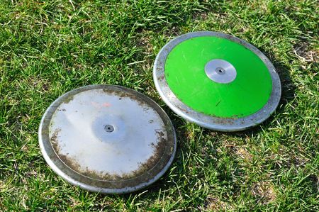 Silver and Green Discus on the Groundの写真素材