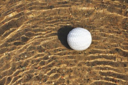 Golf Ball on Sandy Bottom of a Water Hazardの写真素材