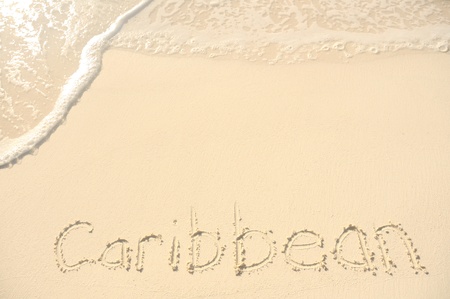 The Word Caribbean Written in the Sand on a Beachの写真素材