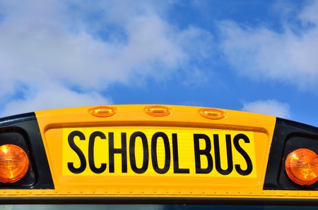 Yellow School Bus with Blue Sky and Cloudsの写真素材