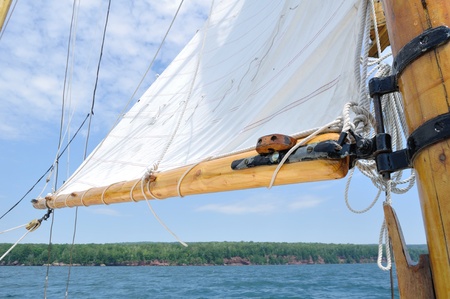 Foresail and Wooden Mast of Schooner Sailboat on a Sunny Summer Day