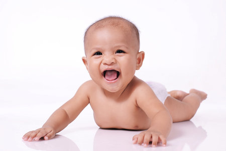 Portrait of happy little asian baby smile girl face down on white floor isolated on white background