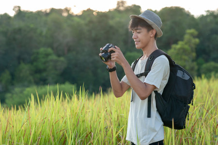 Young Asian traveler photographer on summer wearing knitted hat with backpack looking at  the camera...