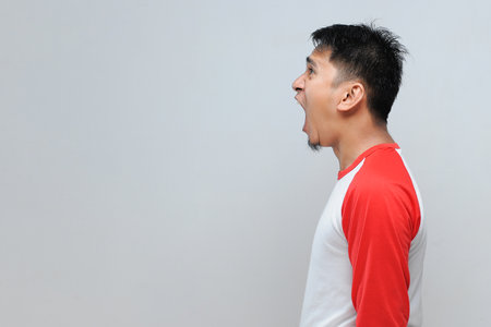 Angry screaming young asian man with copy spaceの写真素材