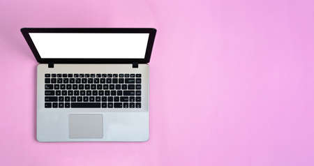 Flat Lay of minimalist silver laptop with screen white display and with copy space for advertising or typing something on pink workspace colorの写真素材