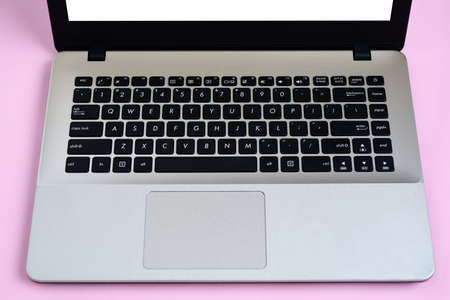 Flat Lay of minimalist silver laptop with white display for copy space on pink workspace