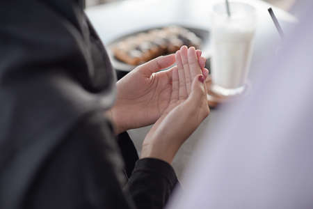 Close up of Muslim woman hand. Holy month of Ramadan. Dua (prayer) for breaking fast and beginning fast. Food and water. Praying, Islam, Religionの写真素材