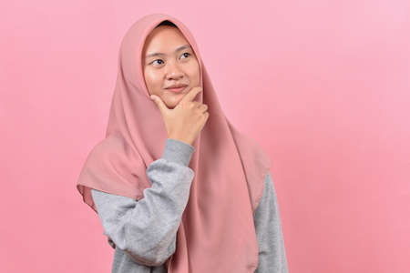 Young Asian muslim woman looking at a copy space or thinking an ideaの写真素材