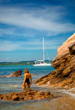 Girl on the ocean shore on the background of a yachtのeditorial素材