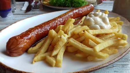Curried fried sausage with french fries and mayonnaiseの写真素材