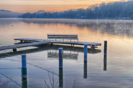 Mooring platform with a bench at Lake Baldeneysee in winterの写真素材