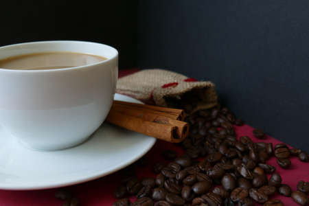 Coffee in a cup with cinnamon and coffee beansの写真素材