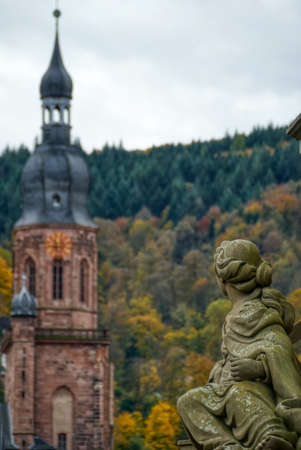 Historical church tower and statue in Heidelbergの写真素材