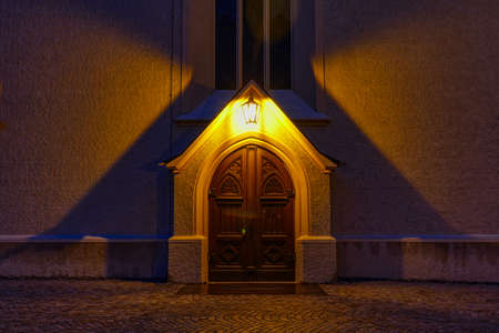Door of a historical church in Garmisch-Partenkirchen at nightの写真素材