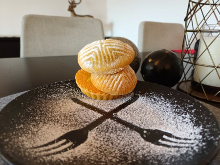 Arabian semolina pastry and powder sugar on a black plate