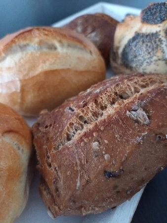 Various bread rolls on a wooden tray