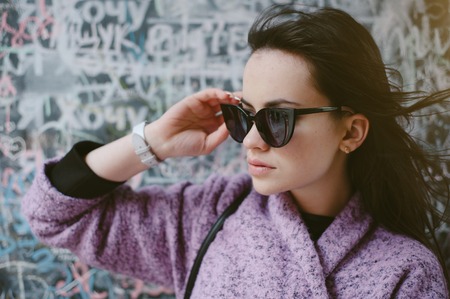 beautiful young model posing near the wall in the city