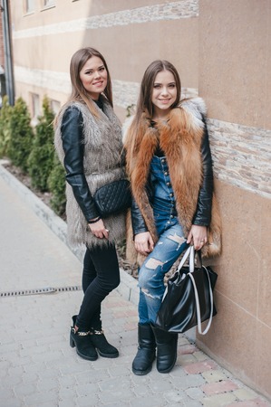 young model walk around town in fur coatsの写真素材