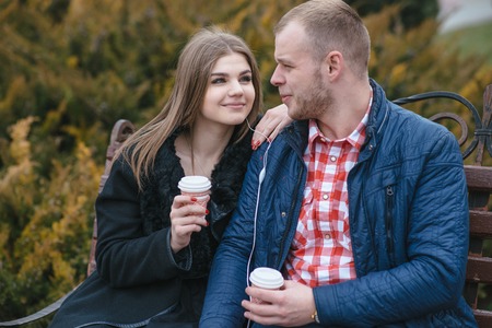 Couple walking through the city, sitting on the bench, photographed and drinking coffee