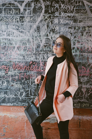 beautiful young model posing near the wall in the cityの写真素材