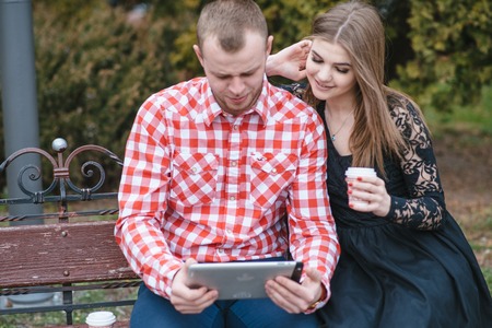 Couple walking through the city, sitting on the bench, photographed and drinking coffeeの写真素材