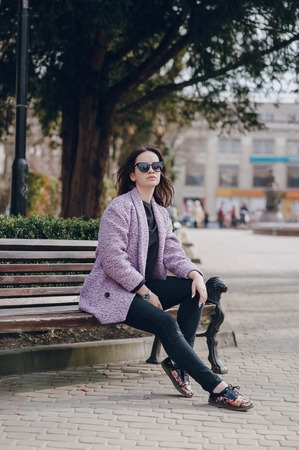 beautiful young model sitting on a bench and posingの写真素材