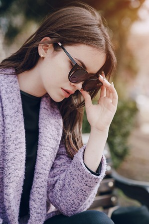beautiful young model sitting on a bench and posingの写真素材