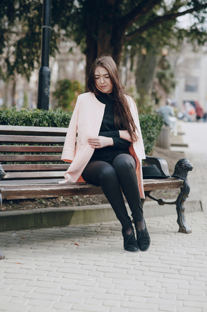 beautiful young model sitting on a bench and posingの写真素材