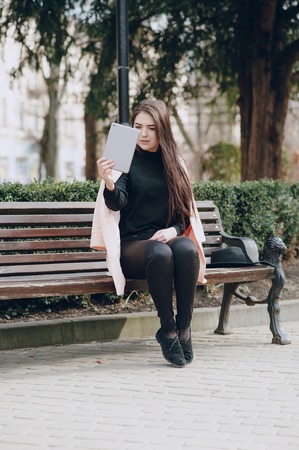 beautiful young model sitting on a bench and posingの写真素材
