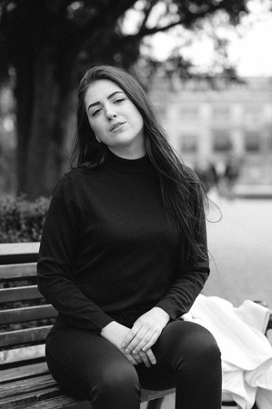 beautiful young model sitting on a bench and posingの写真素材