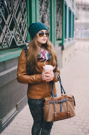 beautiful model walks through the city in a beautiful hat and glassesの写真素材