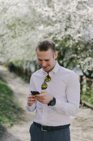 A man walks down the street with the phone and headset