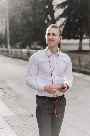 A man walks down the street with the phone and headsetの写真素材