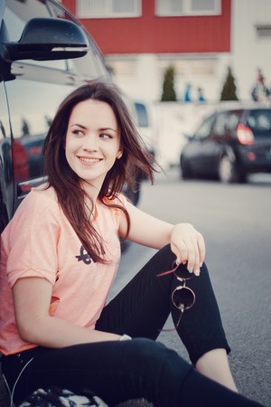 stylish girl walking in the evening city with a phone and a headset