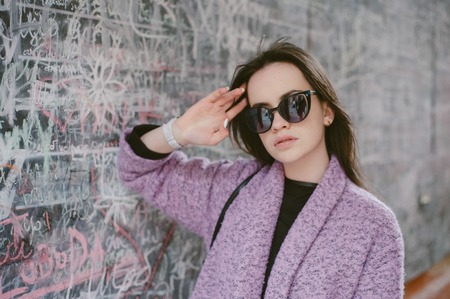 beautiful young model posing near the wall in the cityの写真素材
