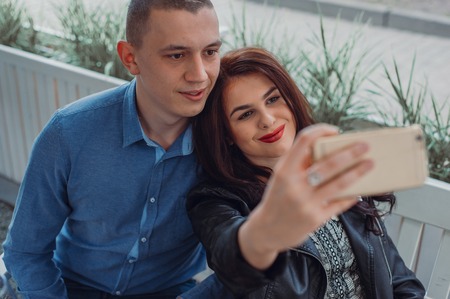 couple walking in the city and taking selfieの写真素材