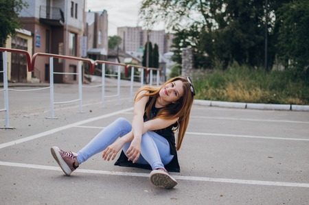 Girl sitting on the streetの写真素材