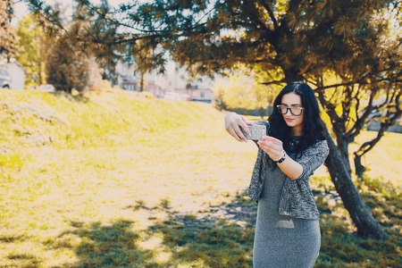 stylish girl walking in the park and make selfieの写真素材