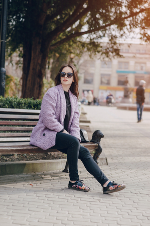 beautiful young model sitting on a bench and posingの写真素材
