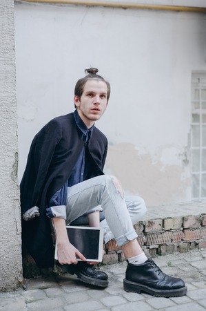 Boy walking ghost town with the tablet.の写真素材