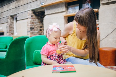 mother and daughter sitting in a cafe, walking in the park and playの写真素材