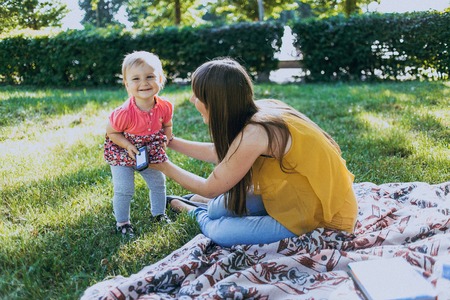mother and daughter sitting in a cafe, walking in the park and playの写真素材